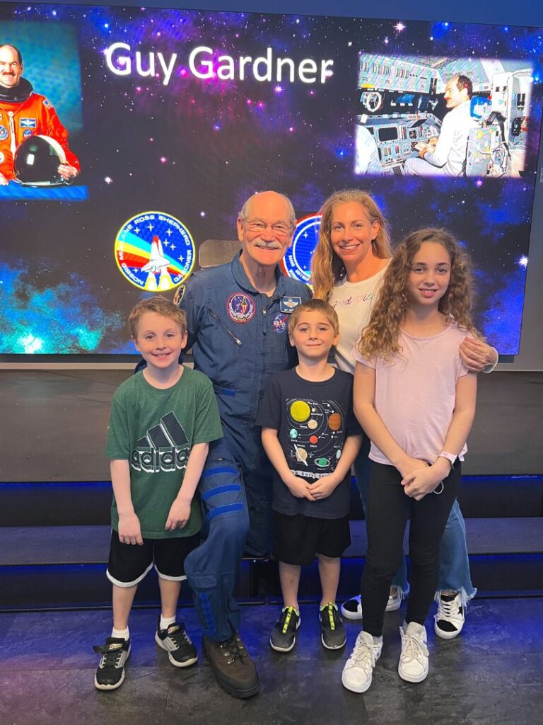 Chat with an Astronaut at Kennedy Space Center Guy Gardner poses for a group family photo