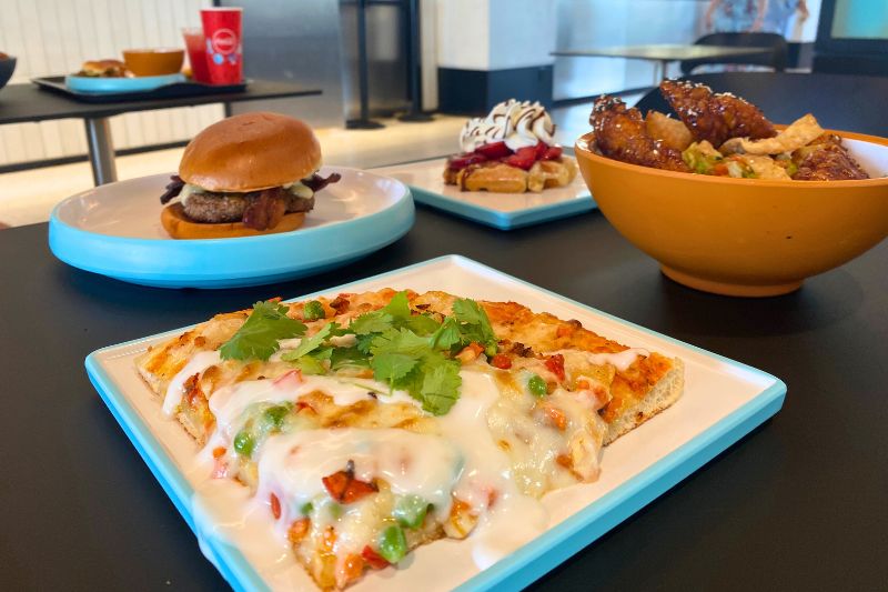 slice of pizza burger, salad and dessert from Connections Eatery EPCOT 