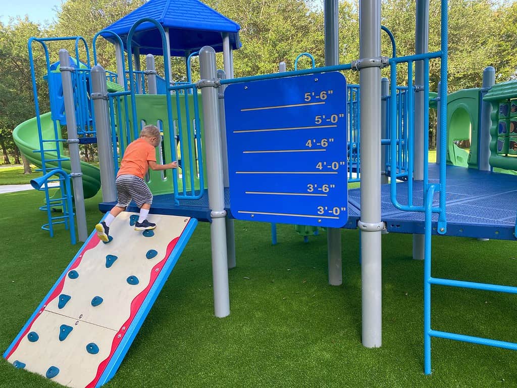 a young toddler climbs the Toddler Playground Secret Lake Park Casselberry Florida