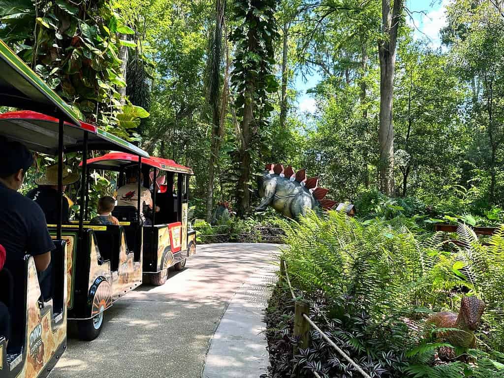 guests on a dinosaur themed train seeing figures at dinosaur world florida