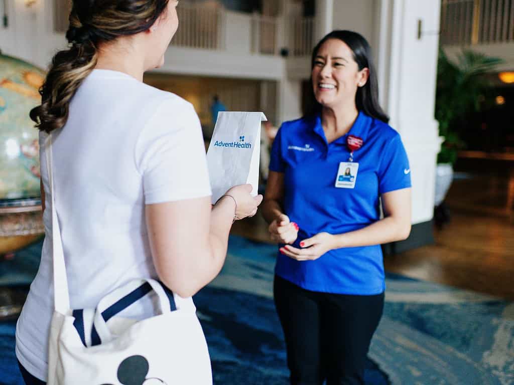 an AdventHealth employee helps a Walt Disney World guest with prescription delivery to a Walt Disney World hotel