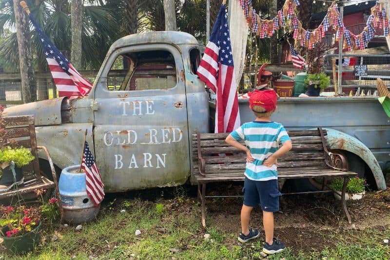 young boy facing away from camera looking at an antique pick up truck at Old Red Barn Geneva Florida 