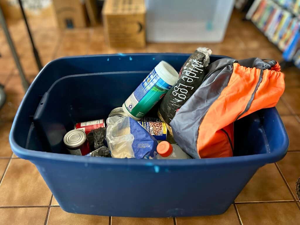 Hurricane Kit with food and water in a blue tub on the floor