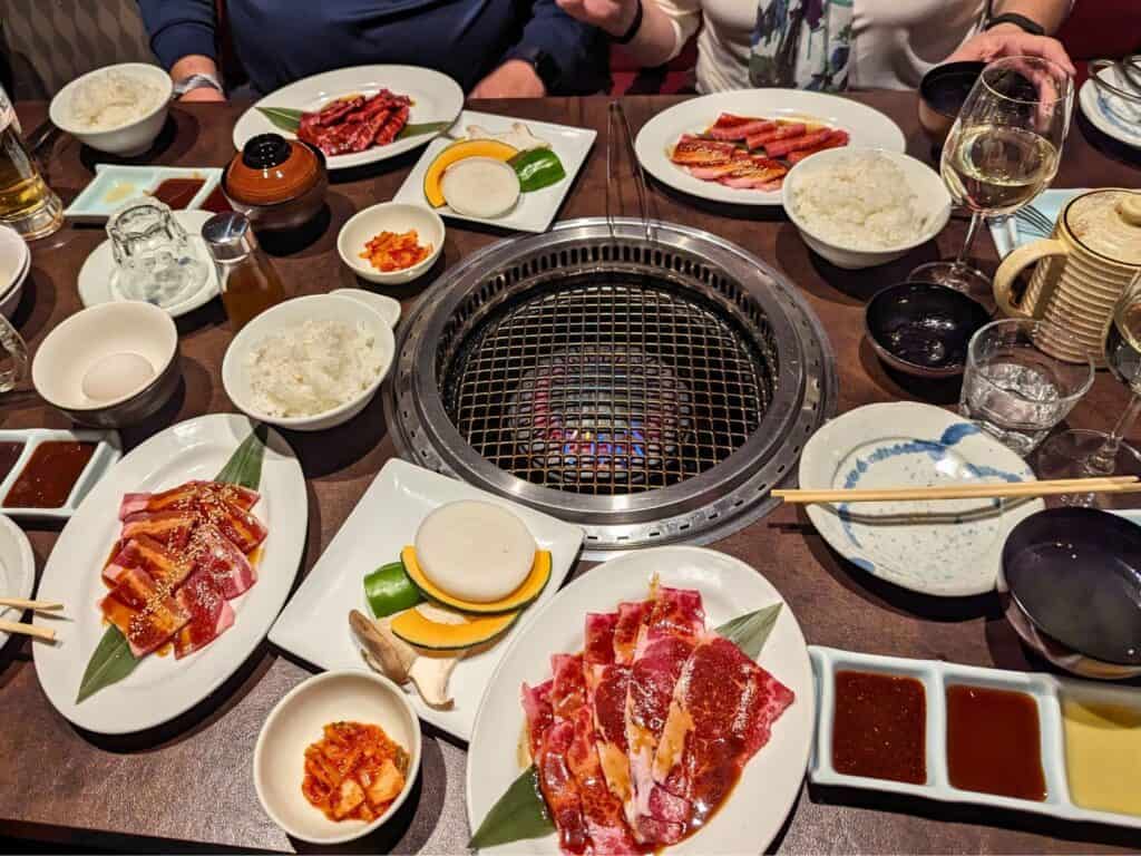 table full of food and open grill at Gyu-Kaku Japanese BBQ Orlando