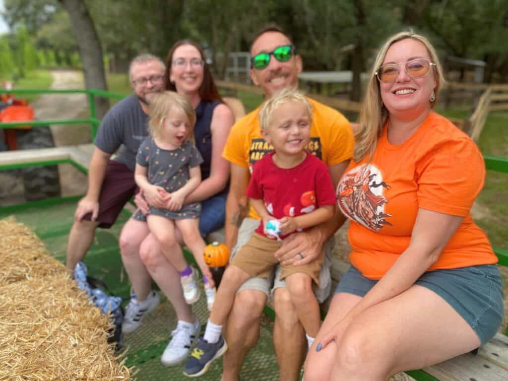 four adults sit with two kids on Hayride at Santa's Farm Near Orlando 