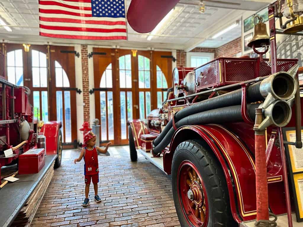 School-Age-Boy-Admires-Vintage-Fire-Truck-Inside-Orlando-Fire-Museum
