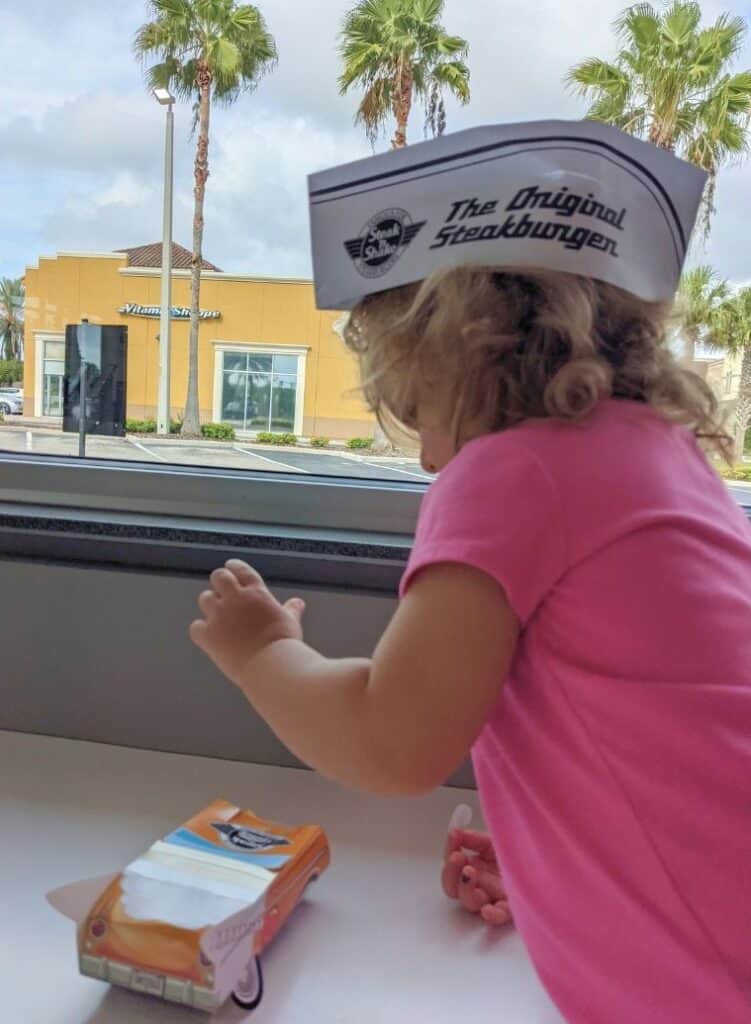 a young girl plays with a paper car at Altamonte Springs Steak and Shake 