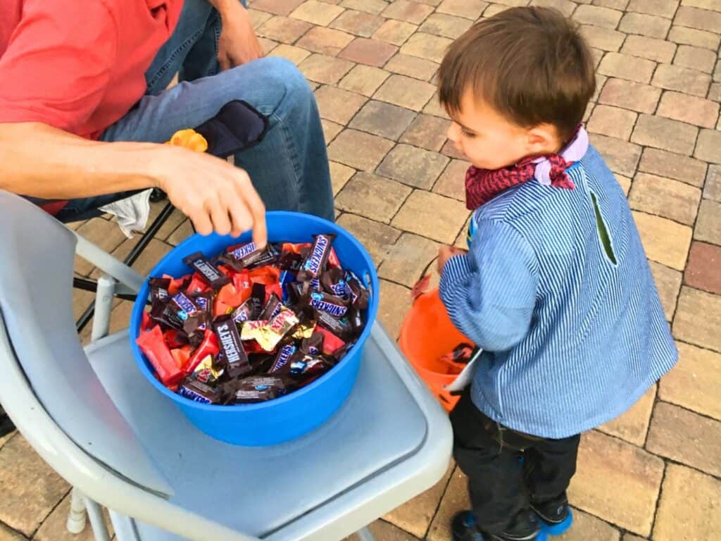 Young Boy Inspects bowl of candy while trick or treating in Orlando 