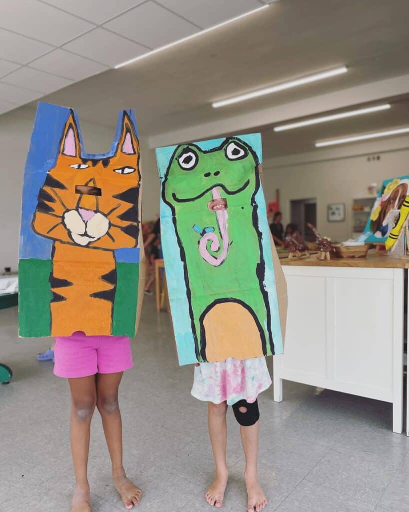two kids poses with art costumes made during a Art Class for Kids in Orlando 