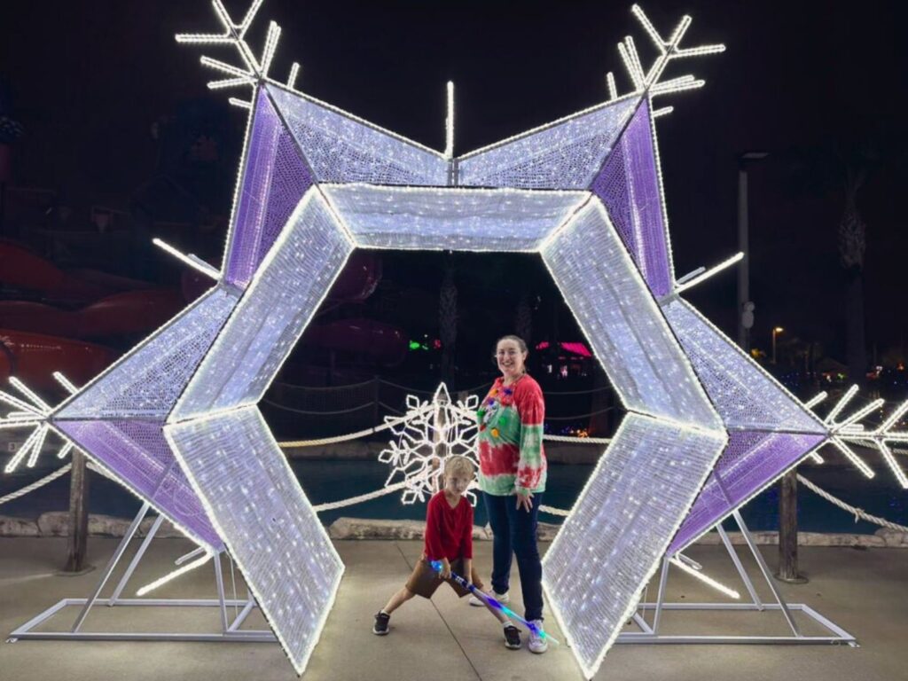 a mom and son pose at Snowflake Photo Spot Holiday Nights at Island H2O Water Park 