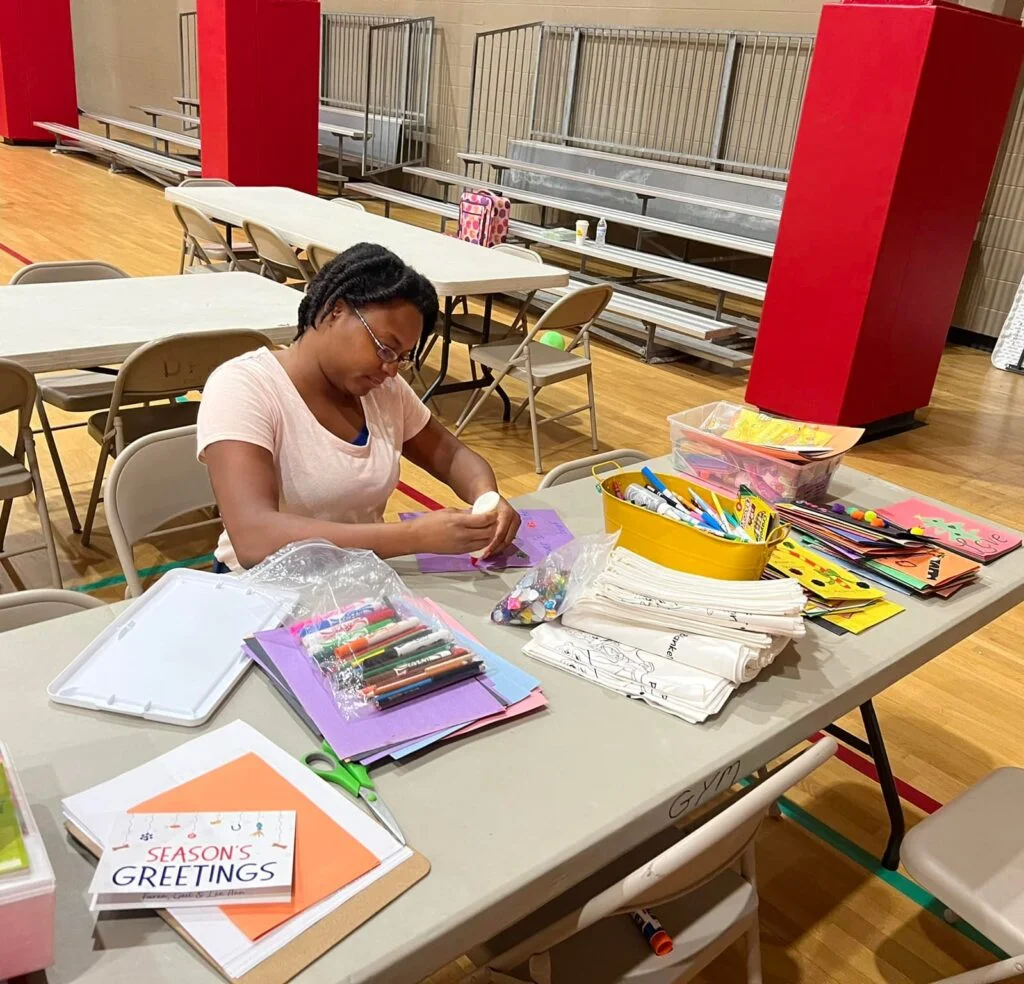 a woman sits at table making christmas crafts Black Homeschoolers of Central Florida @bhcfl