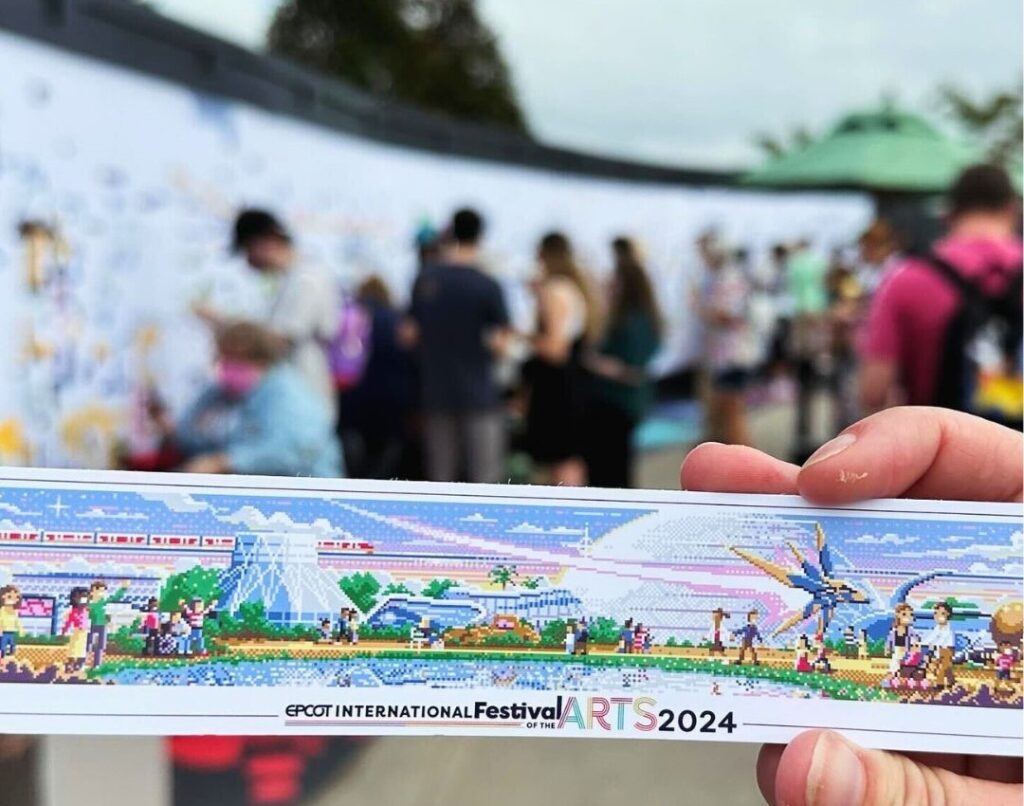 photographer holds the Card with Finished Mural EPCOT Festival of the Arts 2024