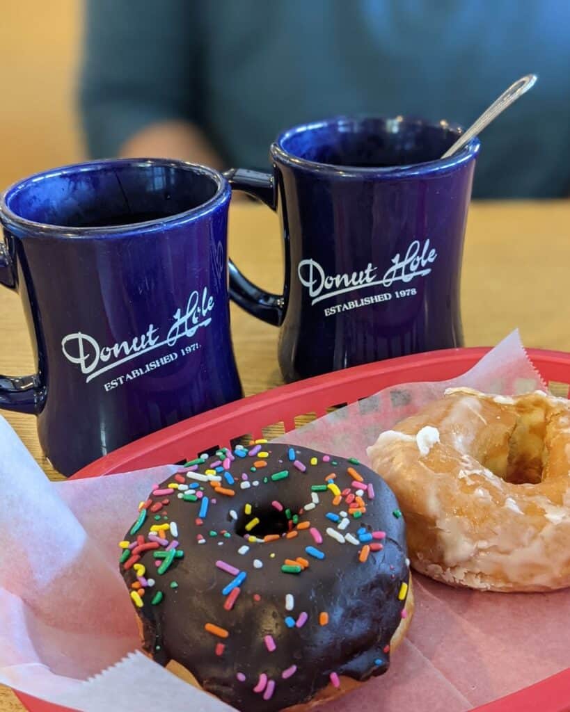 Image of two blue coffee cups and two donuts at the Donut Hole in Destin, FL