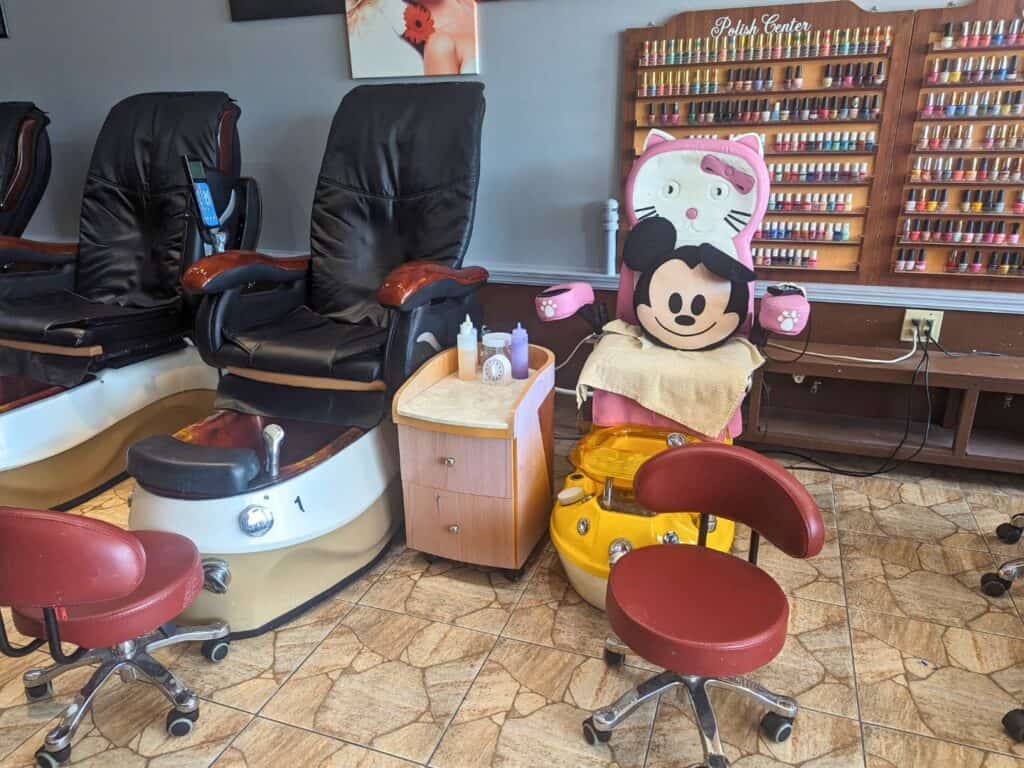 Image of a kids' pedicure station in a salon with a wall of nail polish
