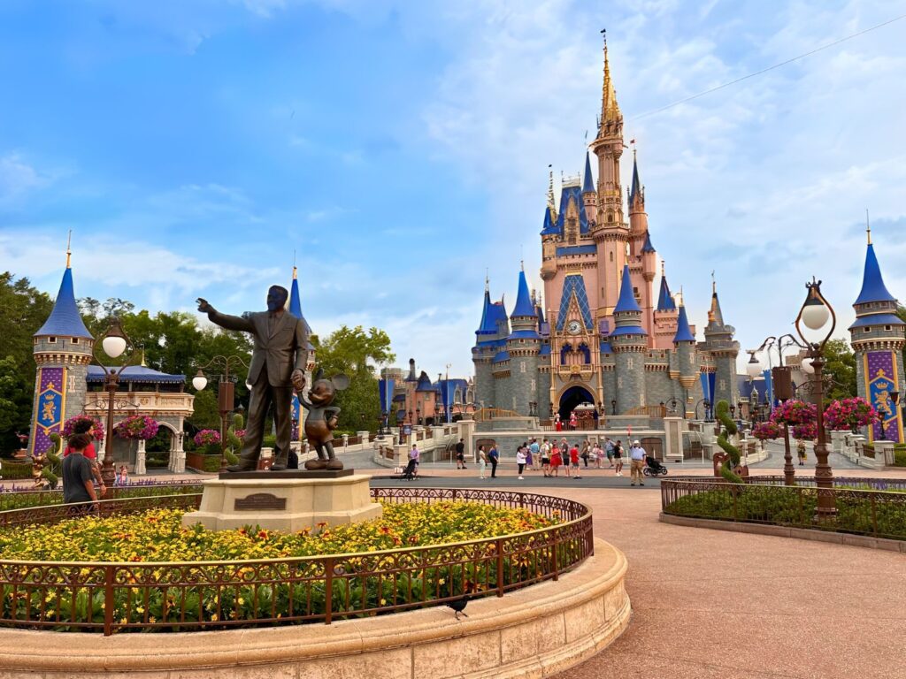 guests gather near Cinderella Castle and Walt Disney Partners Statue at Magic Kingdom 