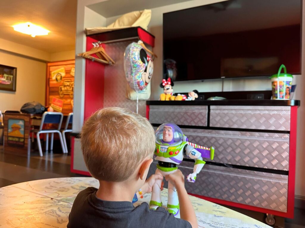 Young Boy playing with Buzz Lightyear Toy inside Cars Family Suite at Disney's Art of Animation Resort 