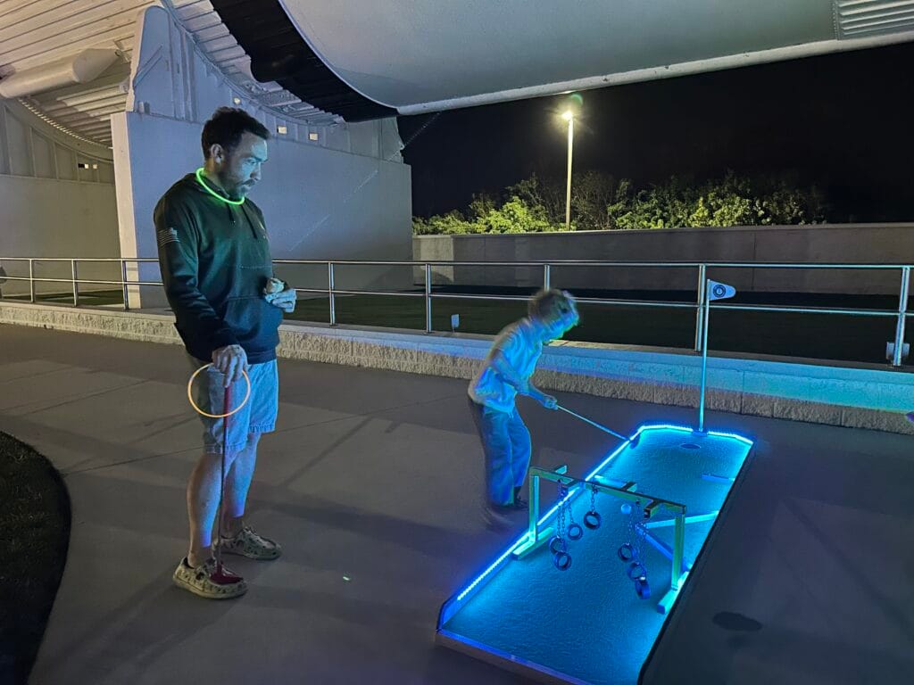 father and son play illuminated golf during Kennedy Under the Stars Event - image by Dani Meyering