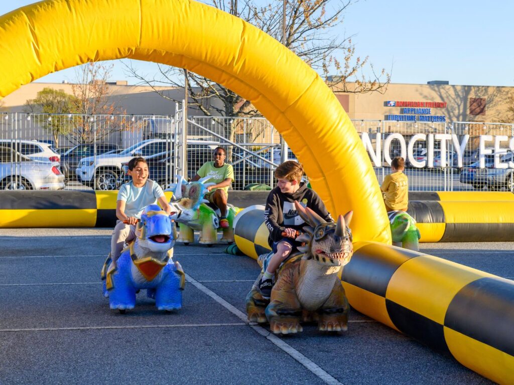 Children racing on ride-on dinosaurs