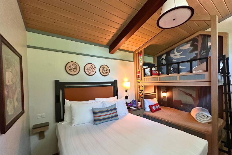 Wide view of Queen bed and bunk beds in bedroom of Disney Vacation Club Cabin Fort Wilderness