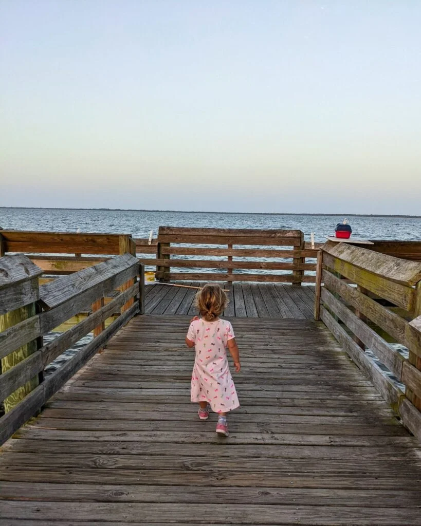Young girl on Manatee Hammock Pier walking towards the water