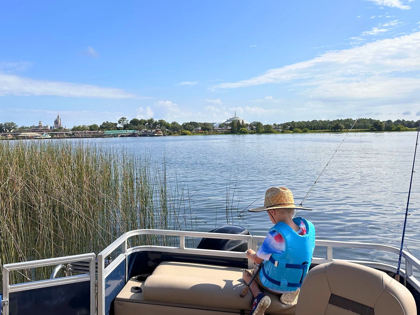 Young boy with fishing pole during fishing at Walt Disney World in front of Magic Kingdom