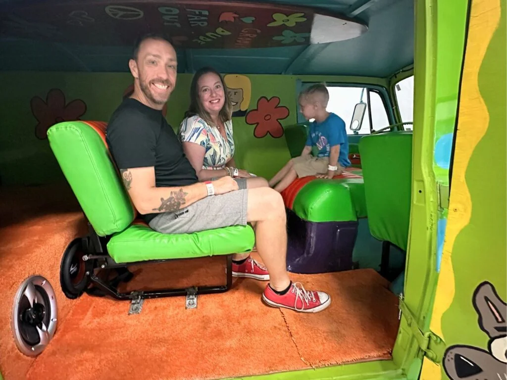 family sits inside Scooby Doo Mystery Machine van at Dezerland Orlando Auto Museum VIP Tour - image from Dani Meyering
