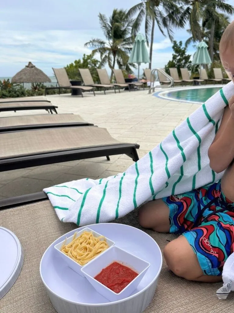 boy eats pasta for lunch at Amara Cay Resort Pool Islamorada