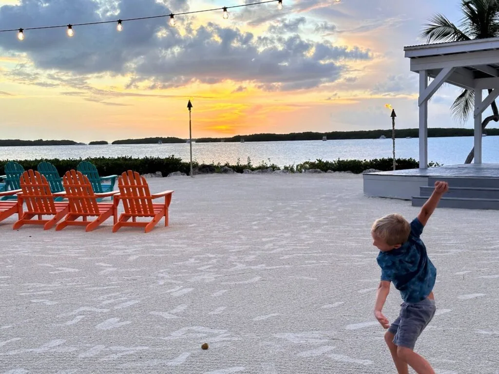 boy plays in sand during Sunset Dining at Morada Bay Beach Cafe