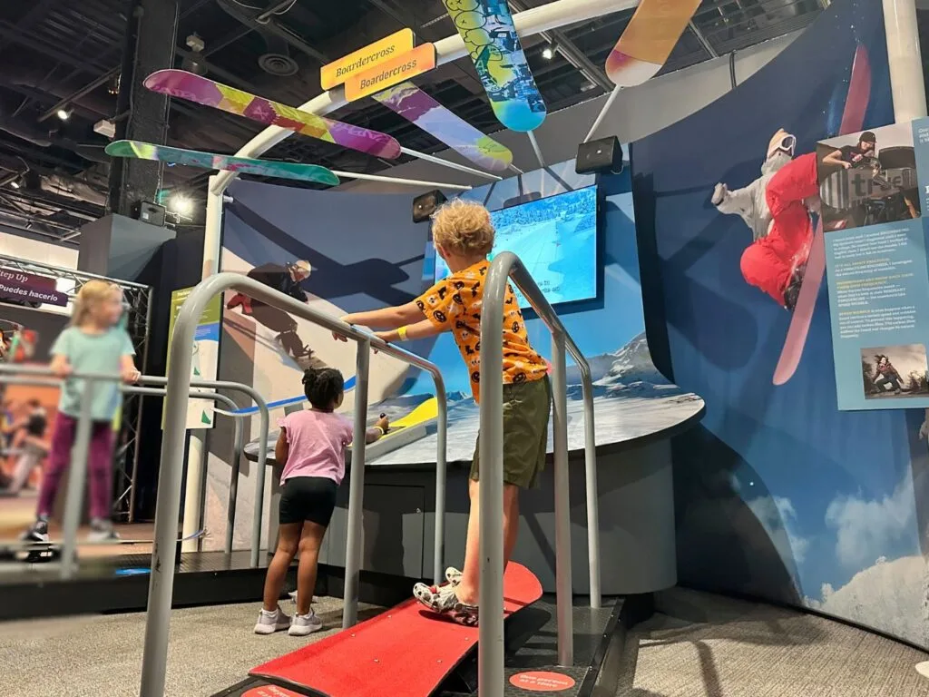 young boy plays on snowboarding area 2TheXtreme Exhibit Orlando Science Center - image by Dani Meyering web