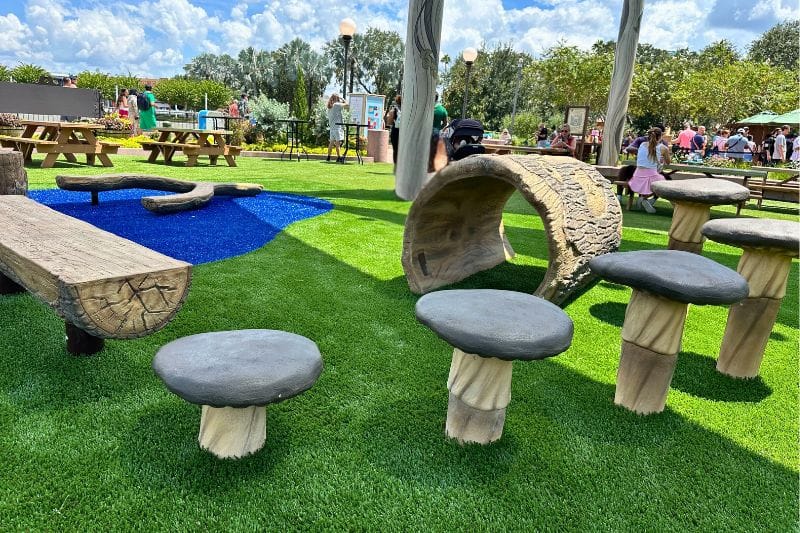 EPCOT Food and Wine Festival 2025 Harvest Hollow Play Area themed log bench and stepping stools - image by Dani Meyering