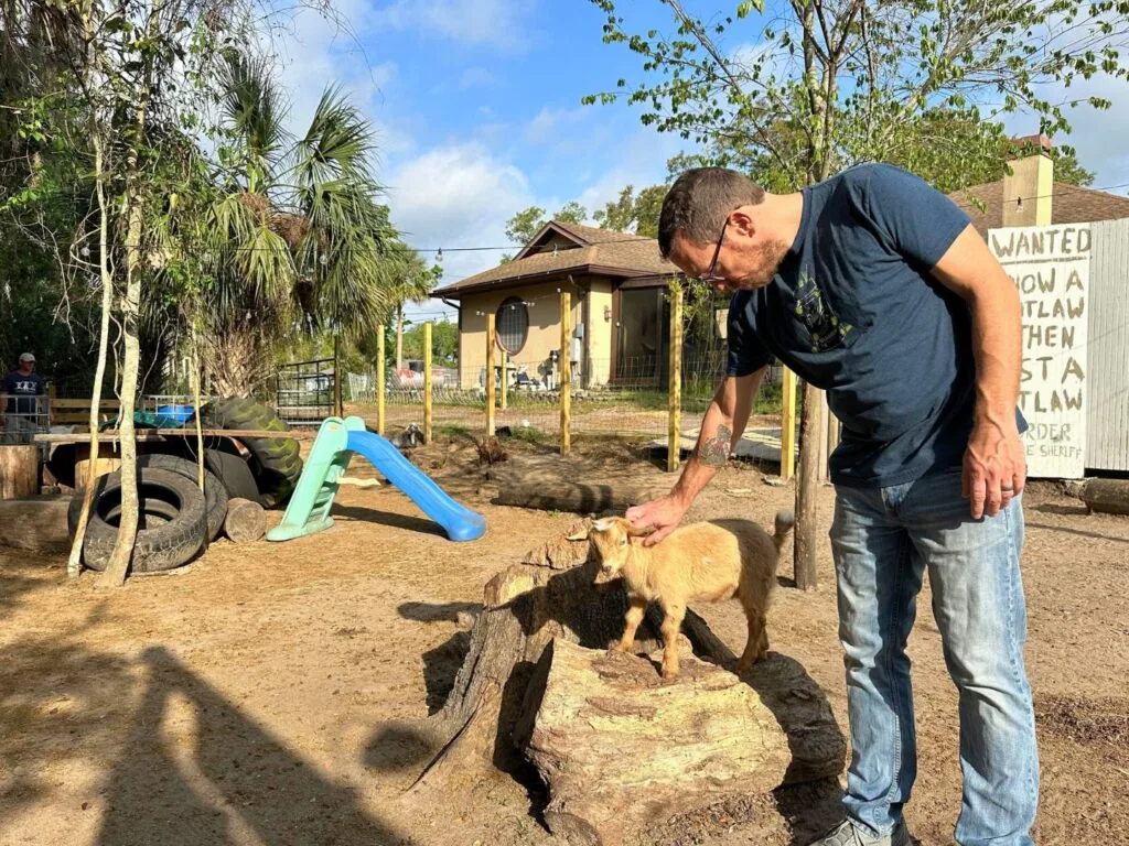 Man pets Small Goat at Bambi's Mini Petting Farm Orlando 