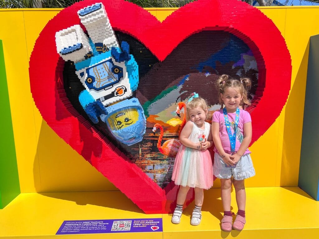two young girls pose with LEGO Festival Brick Heart Photo Opportunity at LEGOLAND Florida - image by Zoe Joiner