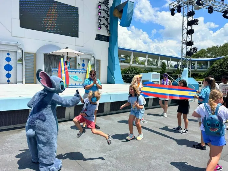 young boy jumps to give Stitch a high five during Galactic Bash Cool Kid Summer Magic Kingdom - image by Dani Meyering