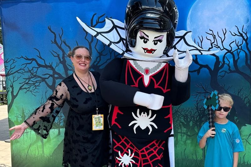 young boy and mom pose with Spider Lady LEGO Character at Legoland Florida - image by Zoe Joiner