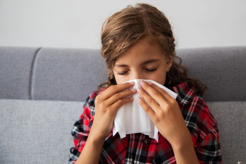 girl on couch uses tissue vitapix from Getty Images Signature