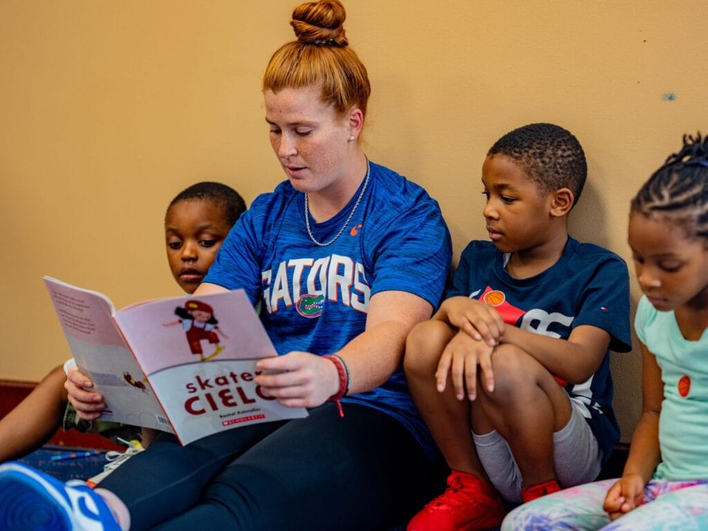 New Worlds Reading adults with three kids reading - image provided by New Worlds Reading Florida