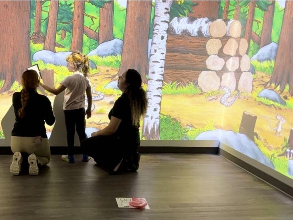 Reading programs for kids in Orlando UCF iRead Gruffalo projection student with two teachers - image provided by University of Central Florida