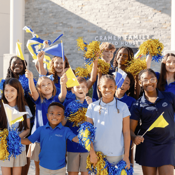 The First Academy students waving blue and yellow flags.