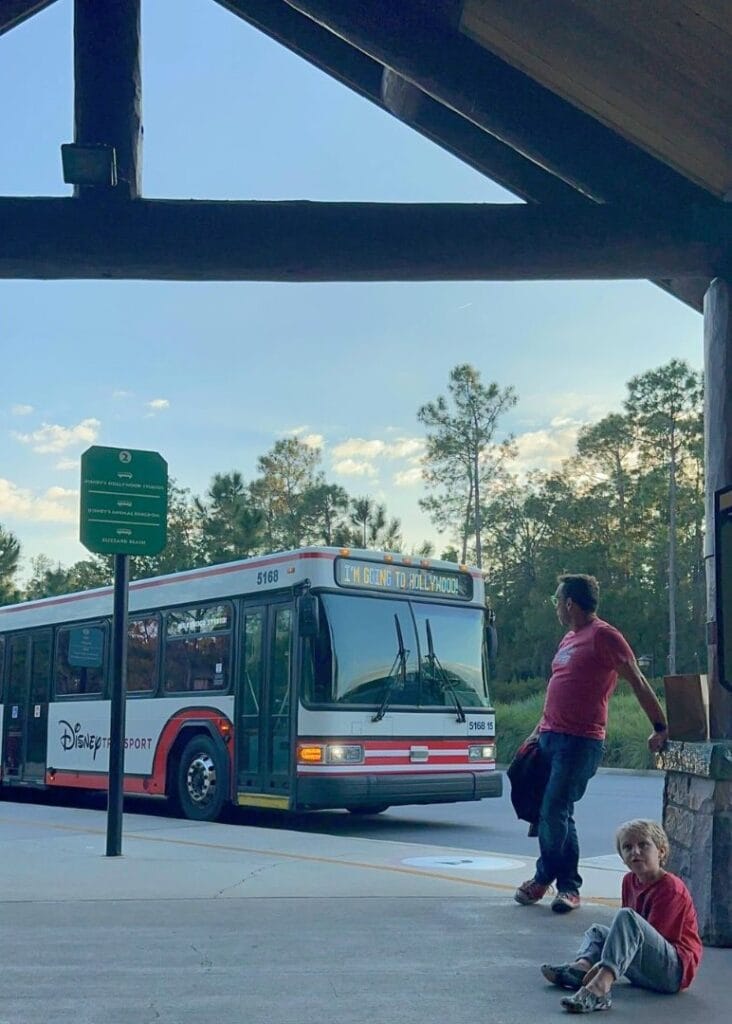 father and son wait at Wilderness Lodge for bus to Hollywood Studios - image by Dani Meyering