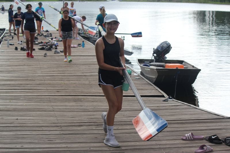 Orlando Area Rowing Society OARS youth camper on dock holding an oar.