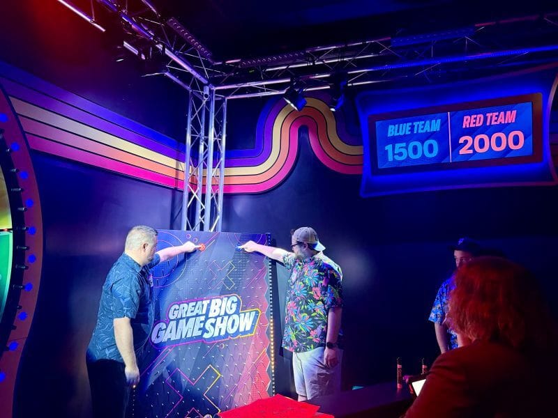 Two men competing during The Great Big Gameshow. Also showing the top right of the screen with the points between the red and blue teams.