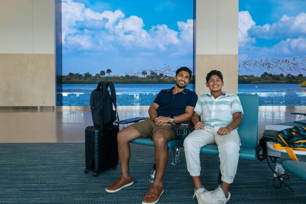 Father and son waiting for a flight in the Gate Seating Area at MCO Airport