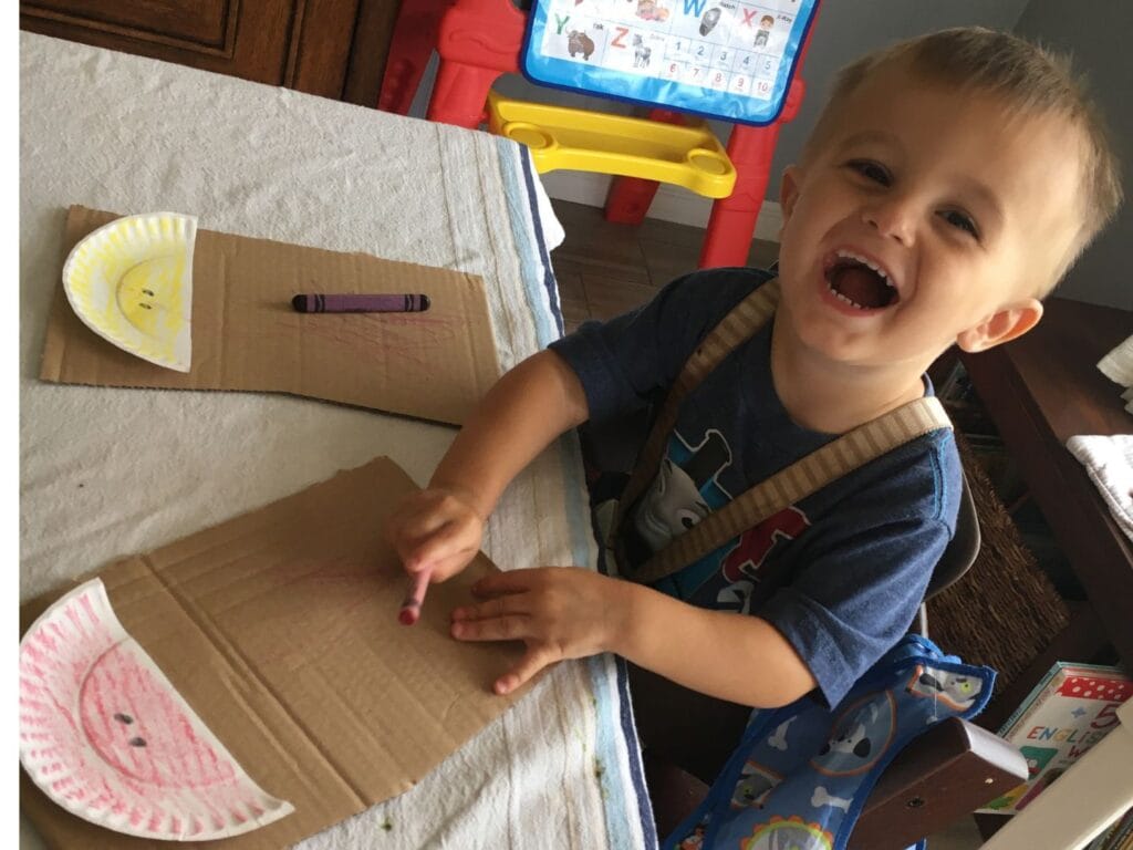 Smiling boy coloring