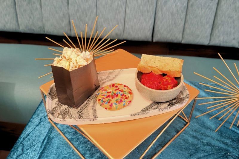 Hurly-Burly Theatre Concessions featuring meatballs, a sugar cookie, and buttered popcorn
