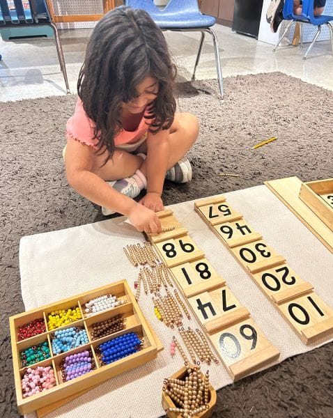 A young girl in elementary school using beads to count