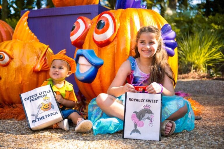 Kids sit with their trick-or-treating bags at SeaWorld Orlando's Halloween Spooktacular