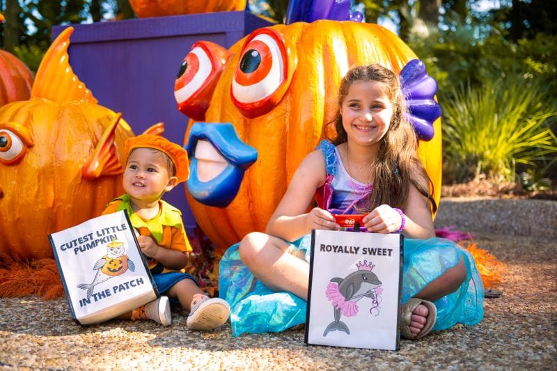 Kids sit with their trick-or-treating bags at SeaWorld Orlando's Halloween Spooktacular