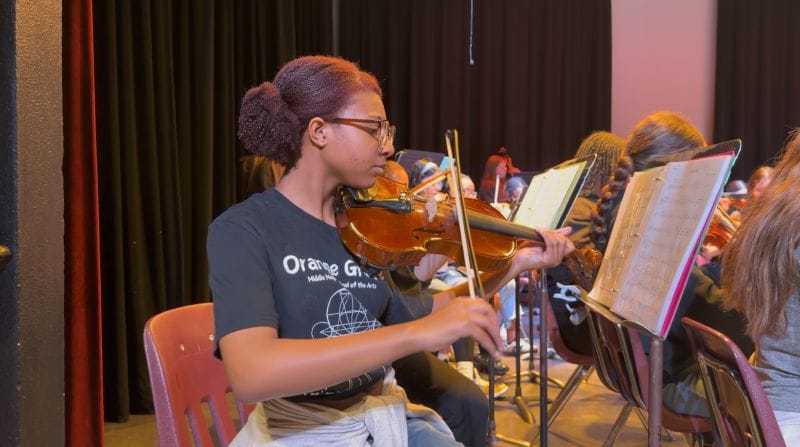 A magnet school student playing the violin